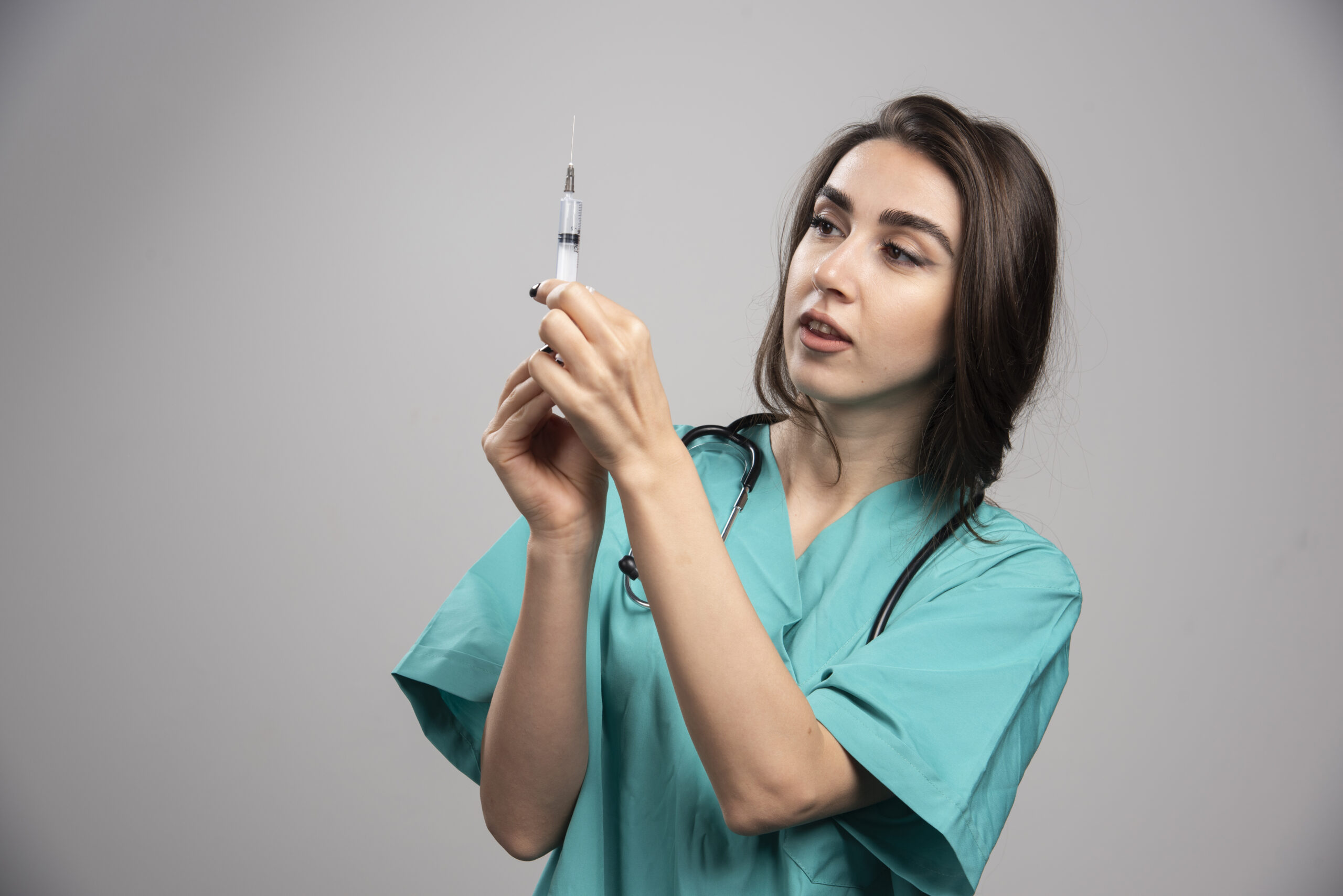 female doctor in uniform preparing syringe