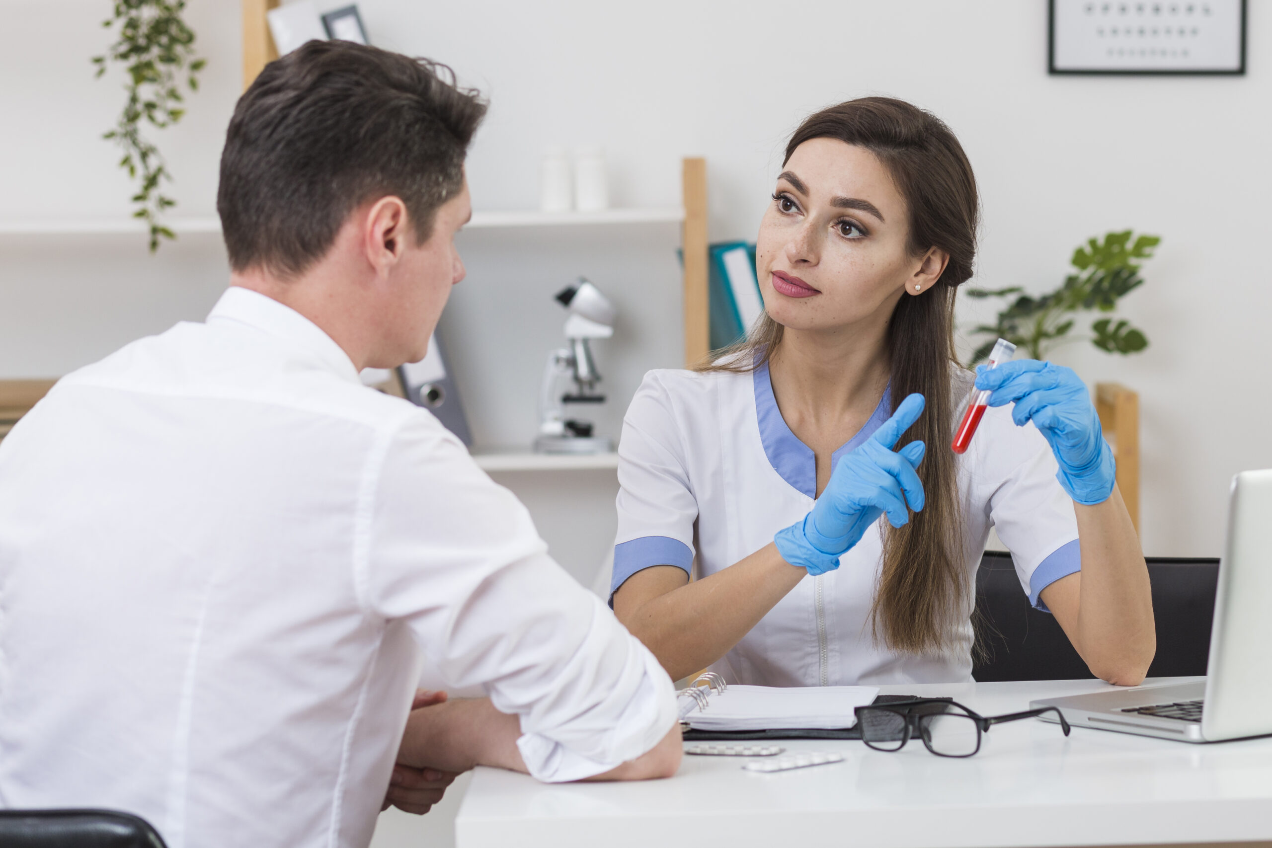 beautiful doctor showing blood sample patient