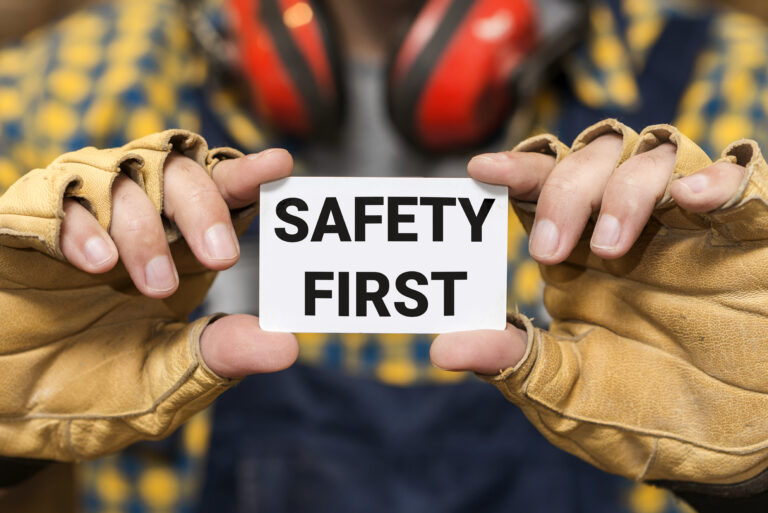front view hands holding safety first sign